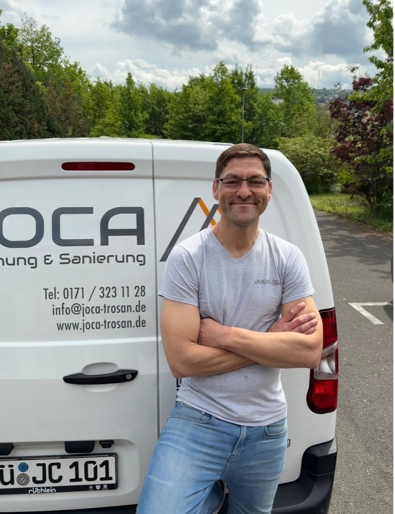 Joachim Callian, Inhaber JOCA Trocknung & Sanierung, vor dem JOCA-Firmenwagen in Würzburg